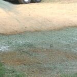 man watering newly laid grass seed