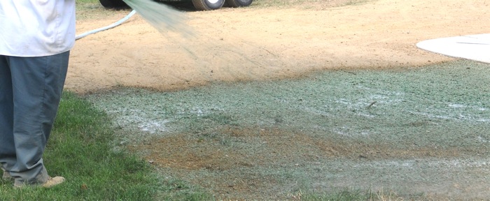 man watering newly laid grass seed